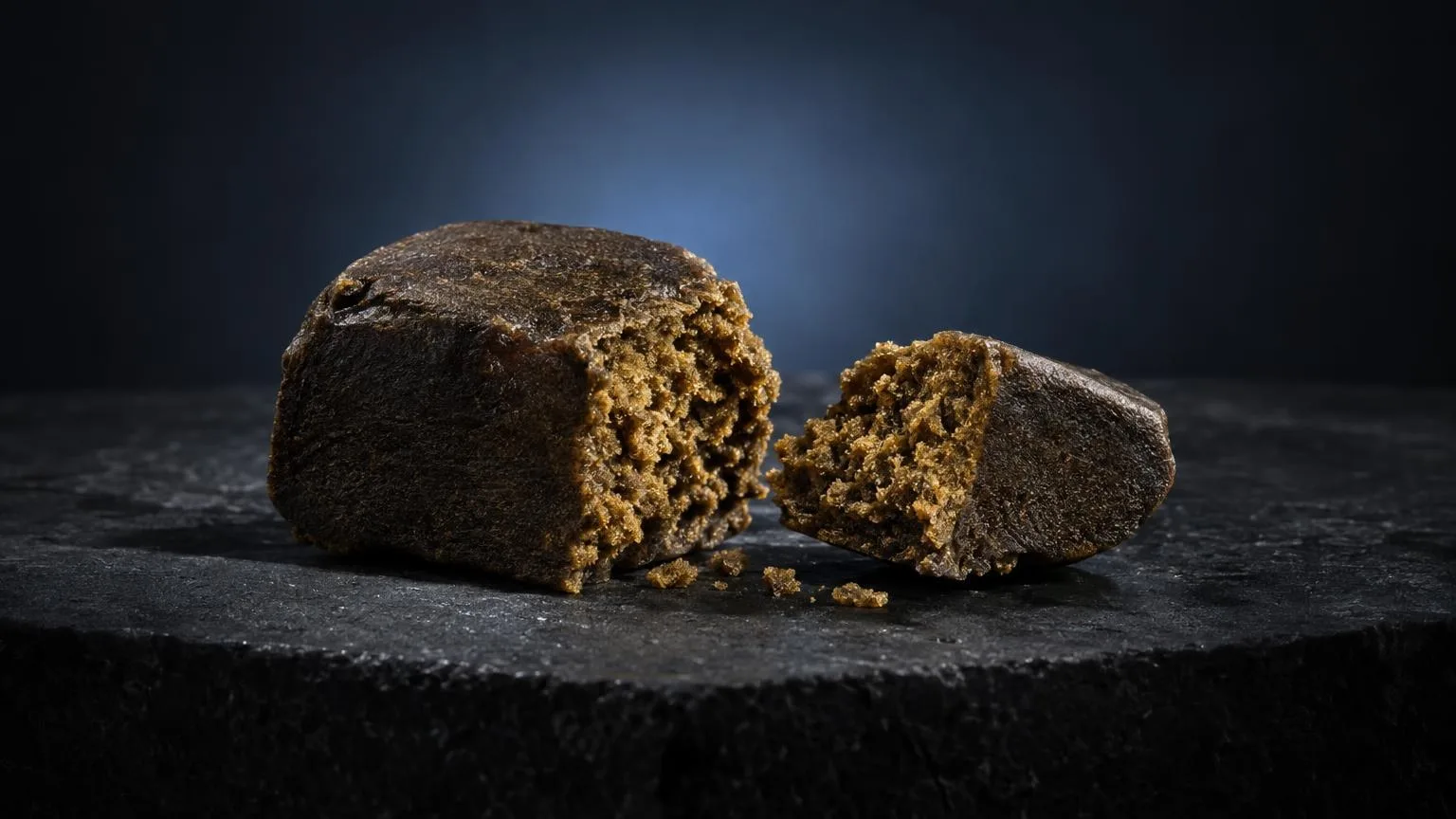 Selbstgemachter Hash-Kakao mit bröckeliger Textur auf schwarzer Oberfläche, zeigt die poröse Struktur des Produkts