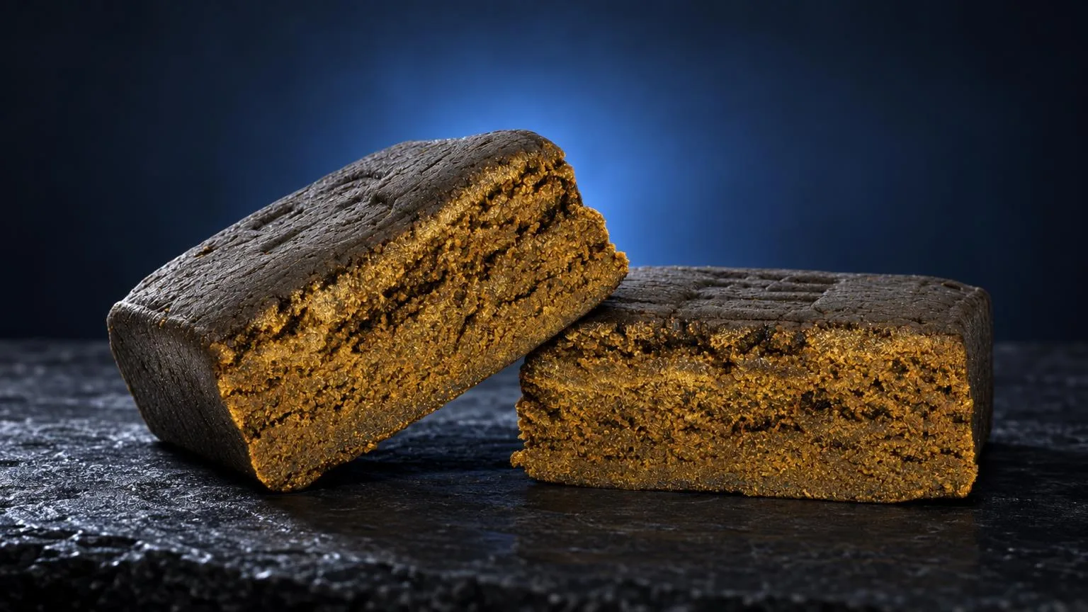 Zero Zero Hash: zwei Stücke Triple Zero mit goldgelber Krume und dunkelgrauer Oberfläche auf schwarzem Untergrund